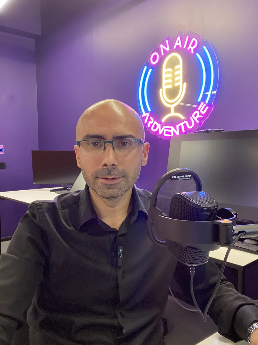 Mehmet Akif Kuşaslan podcast çekiminde, stüdyoda mikrofon başında